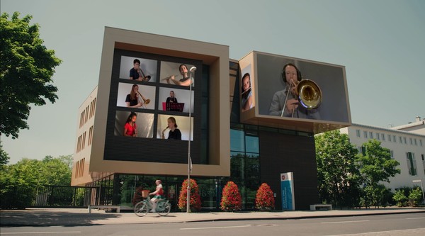 Während die Gänseliesel durch die Stadt fährt erscheinen in den Fenstern immer wieder einzelne Aufnahmen der Musikerinnen und Musiker – hier in der Musikschule am Berliner Ring. Foto: Screenshot