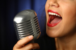 Eine Frau singt in ein Mikrofon